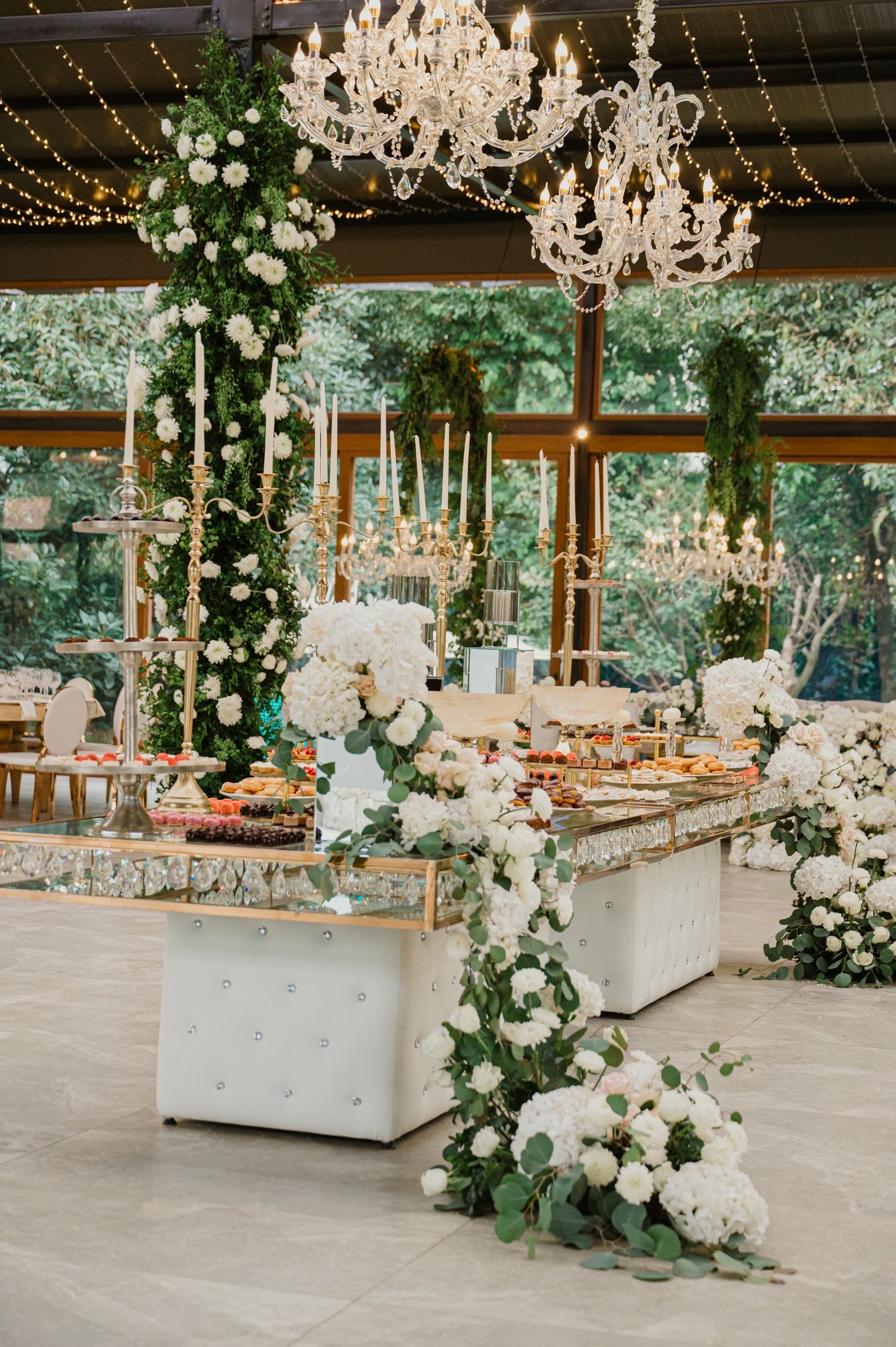 Mesa de pastel bajo candelabro floral