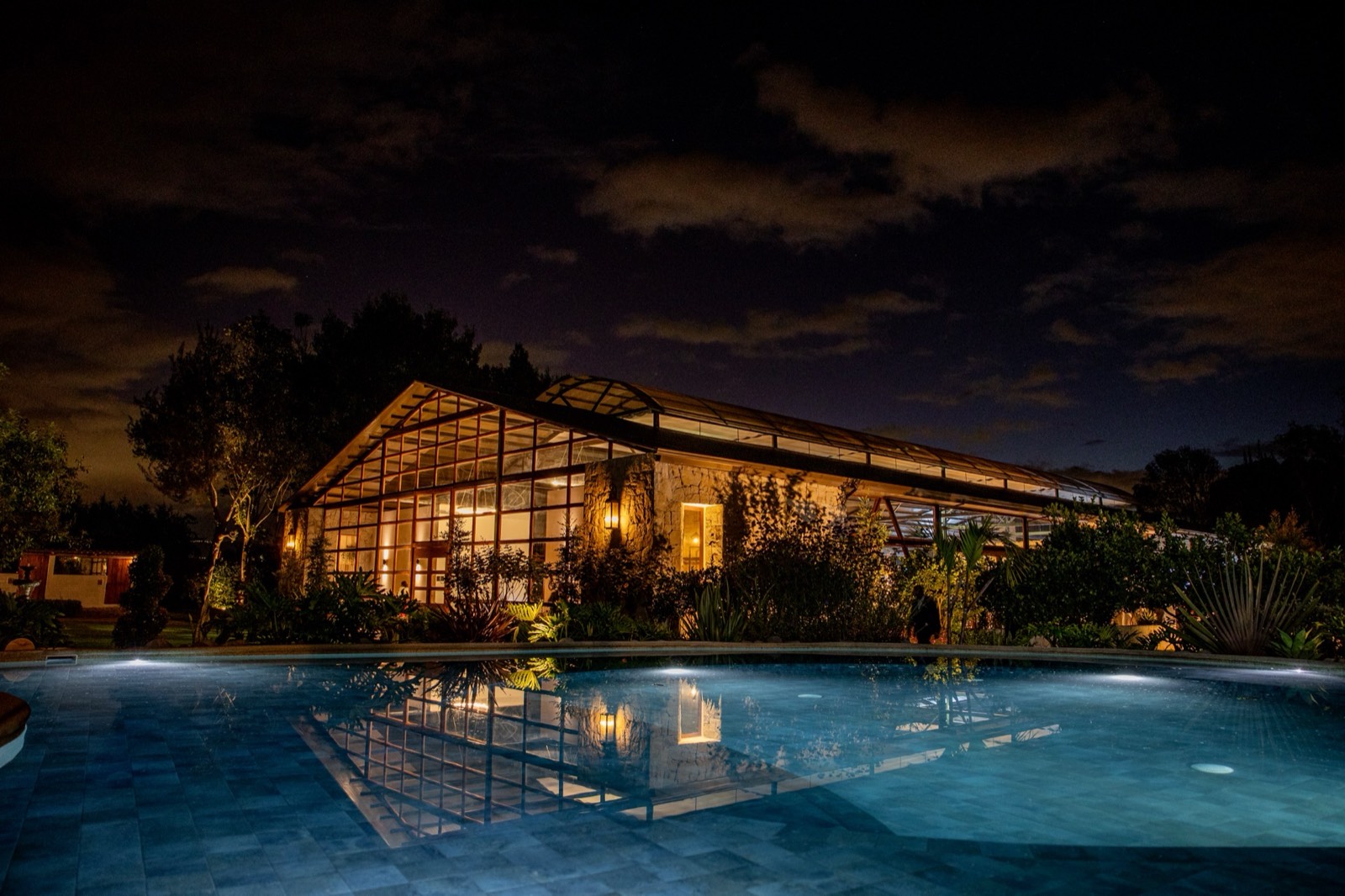 Villa Pietra iluminada de noche junto a la piscina