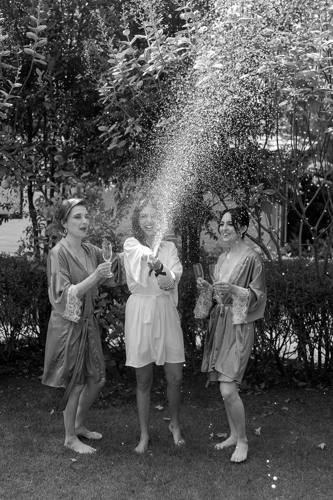 Damas de honor celebrando con brindis, en blanco y negro