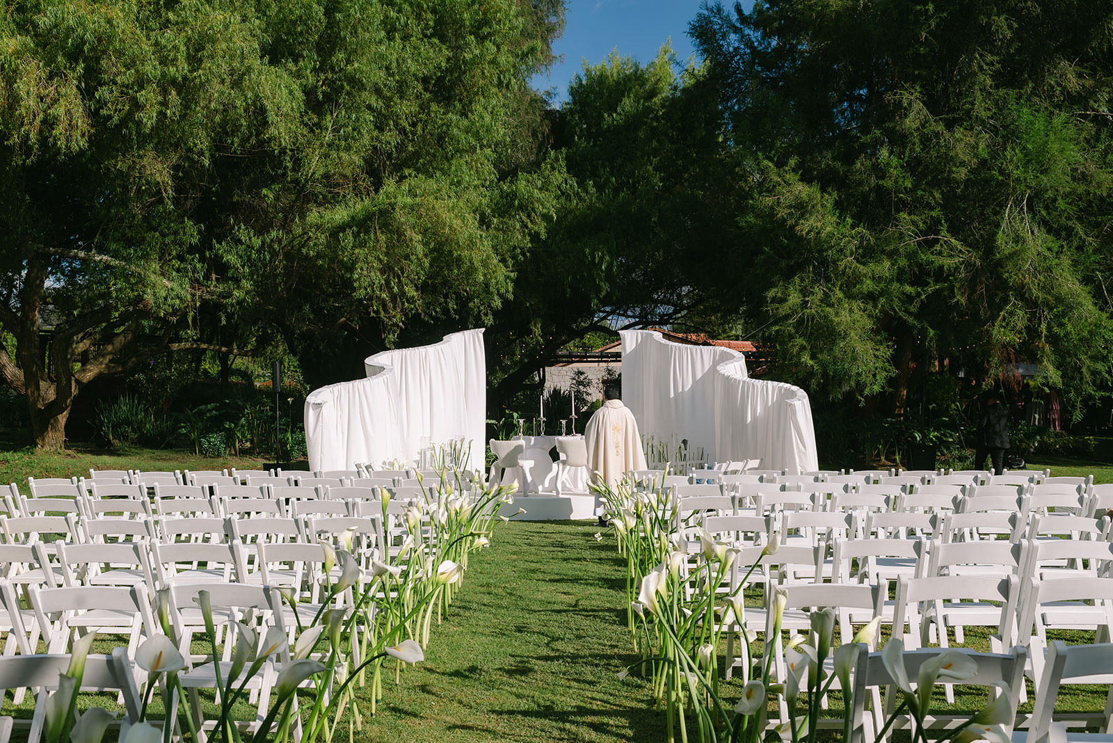 Altar de ceremonia con arco blanco en el jardín