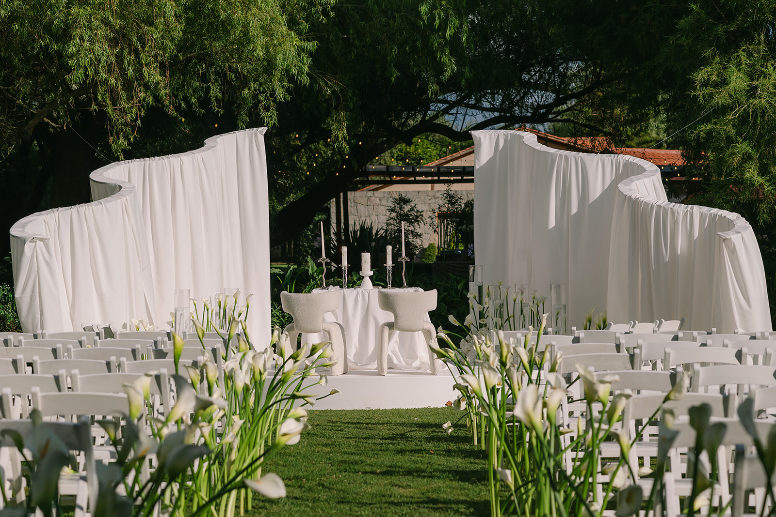 Arco de ceremonia decorado con follaje y flores blancas