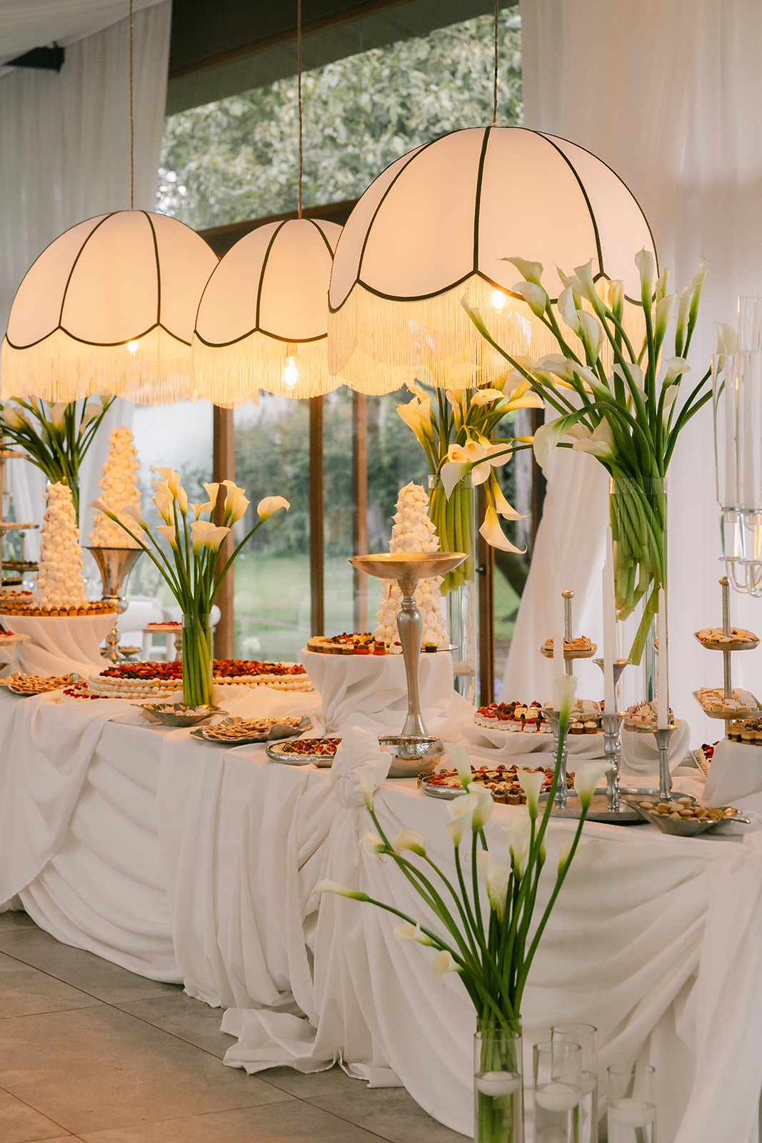 Mesa de postres iluminada con candelabros