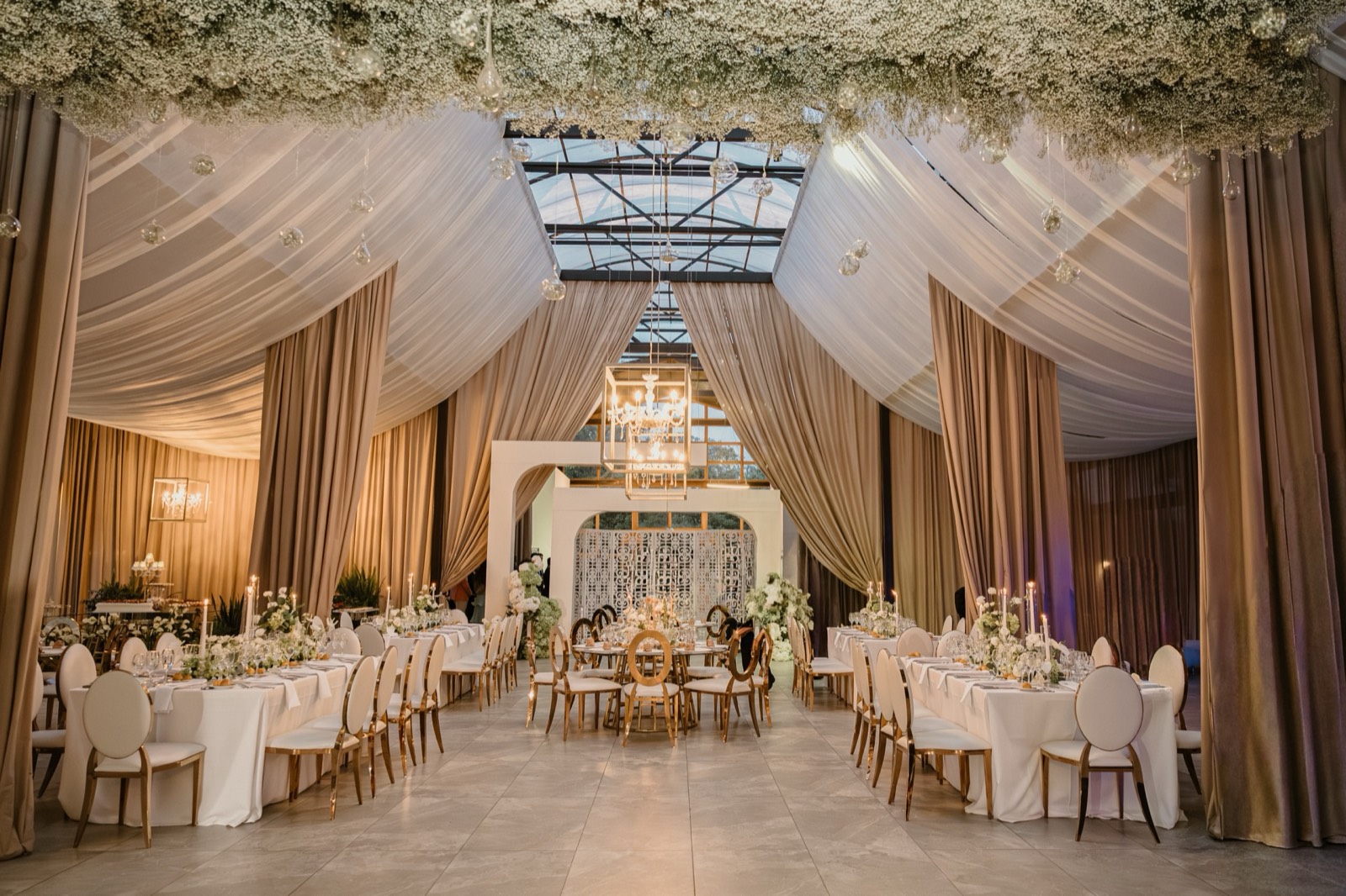 Carpa de recepción decorada con drapeados y flores colgantes