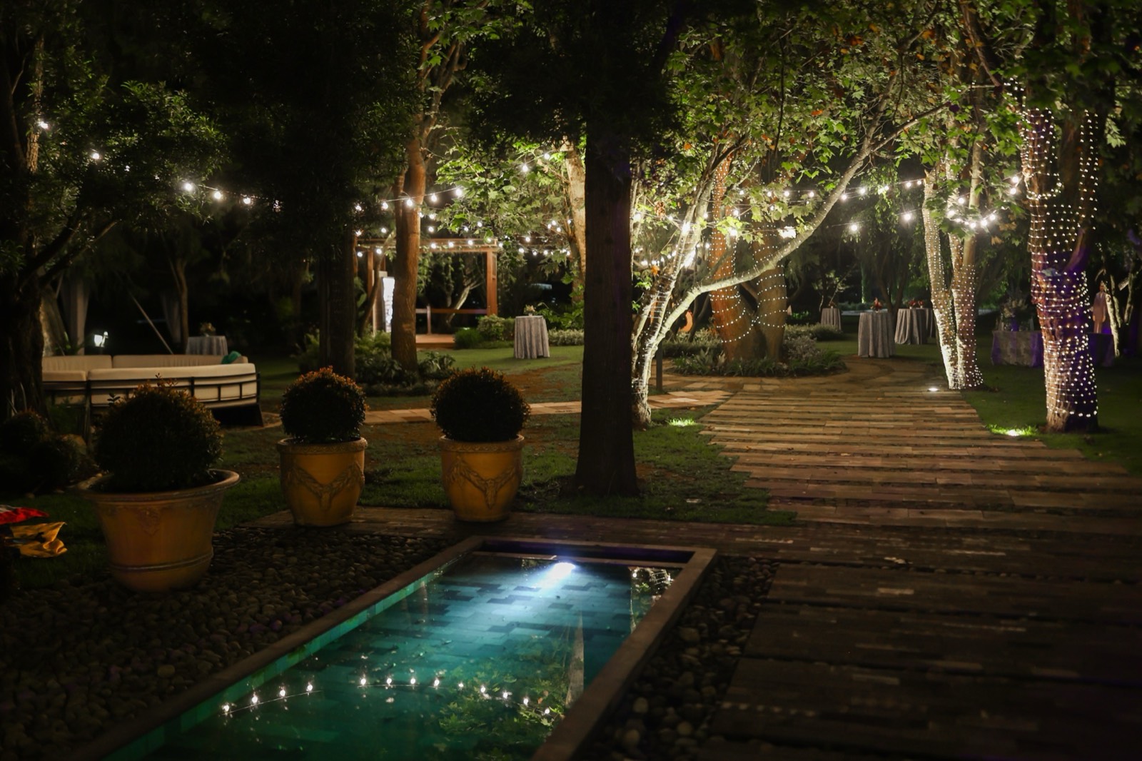 Piscina y deck iluminados de noche en Villa Pietra