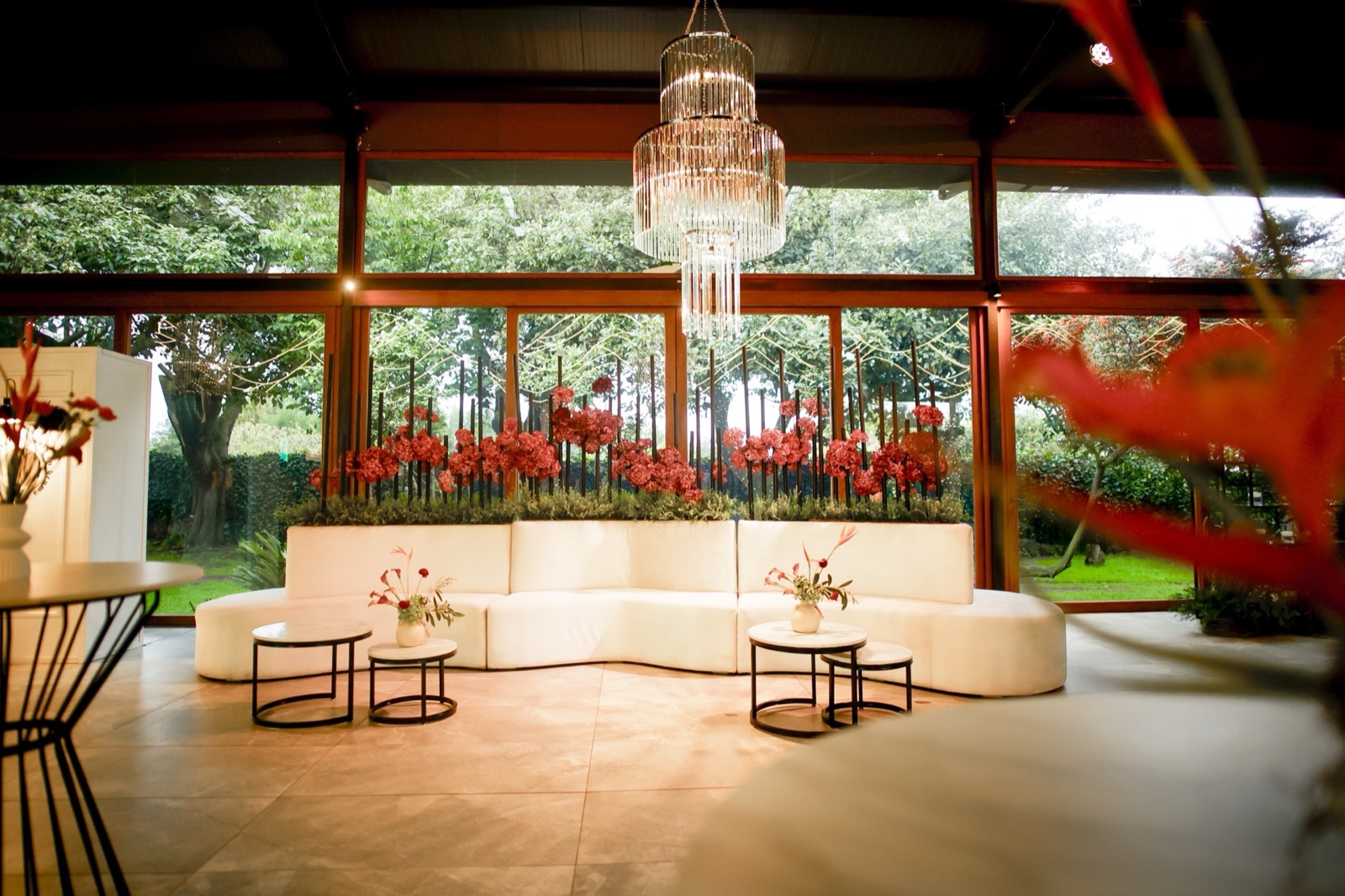 Área lounge con sofás curvos y arreglos florales