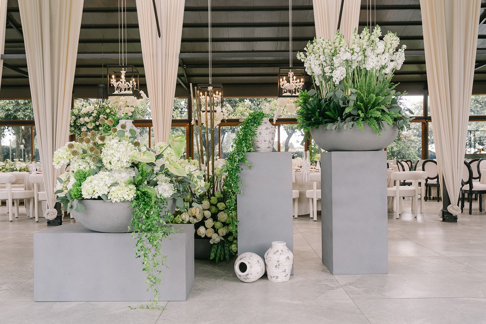 Arreglos florales sobre pedestales en salón de eventos