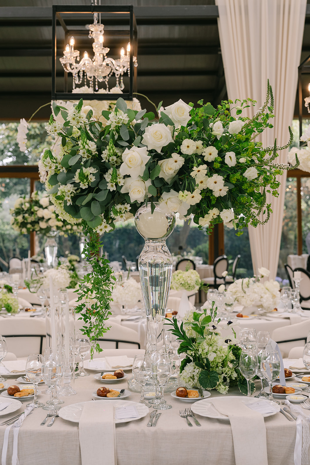 Centro de mesa floral alto sobre mesa de recepción