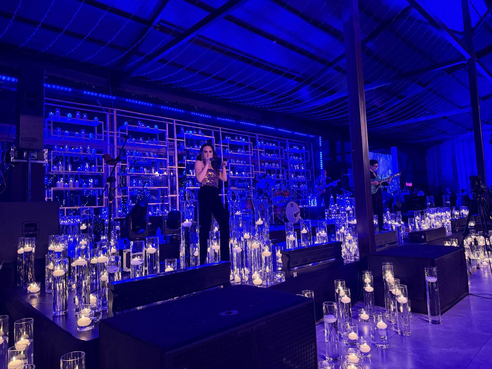 Cantante en escenario con iluminación azul en Candle Night