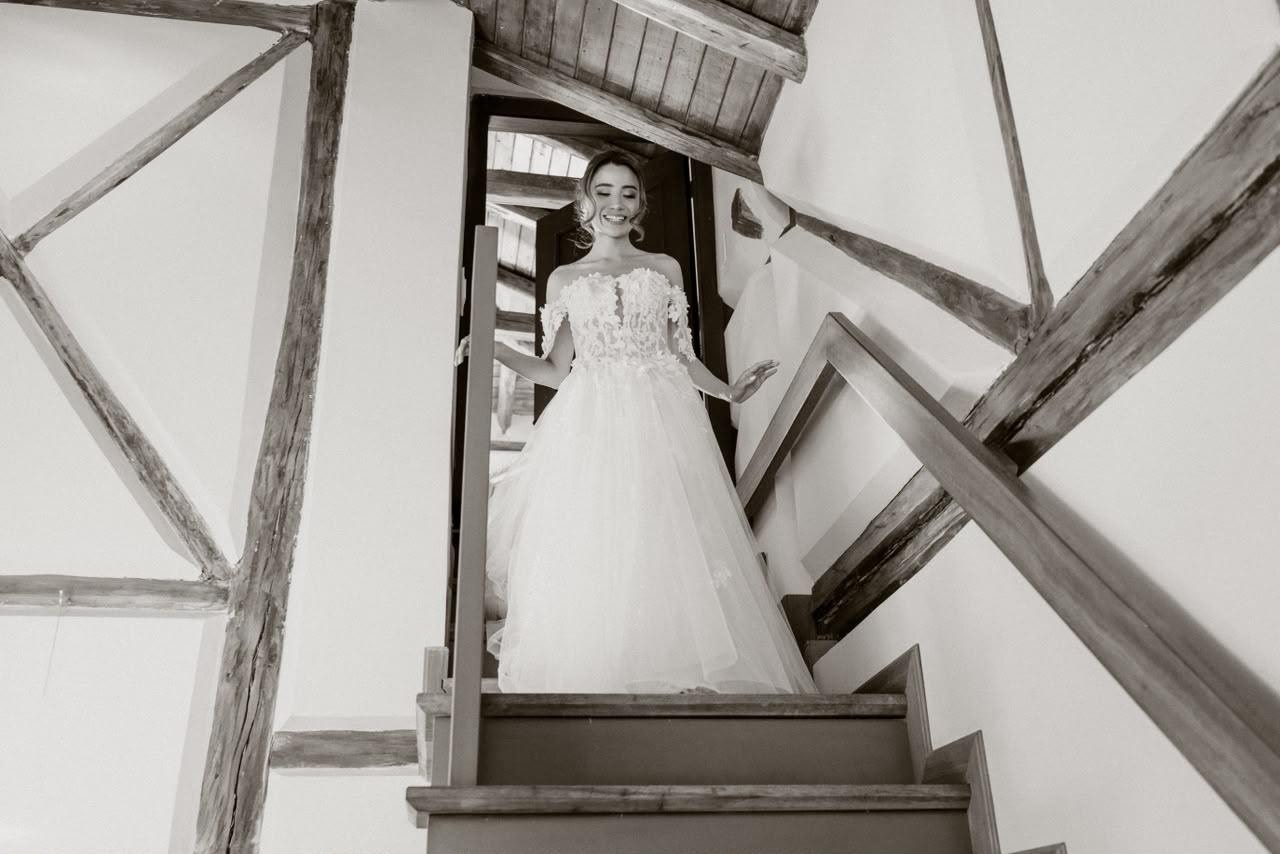 Novia bajando por una escalera de madera rústica