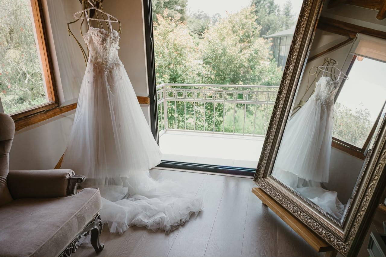 Vestido de novia colgado frente al espejo