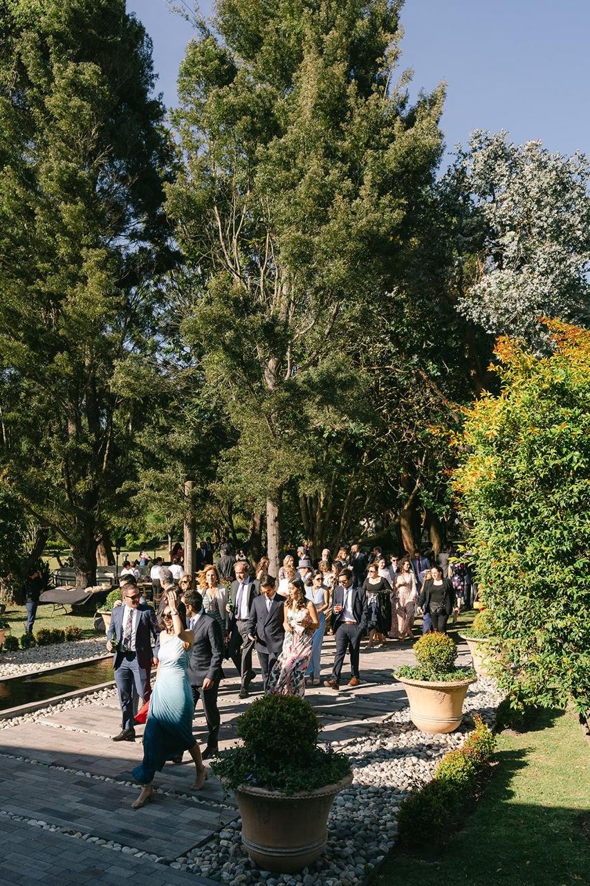 Invitados caminando hacia la ceremonia entre jardines