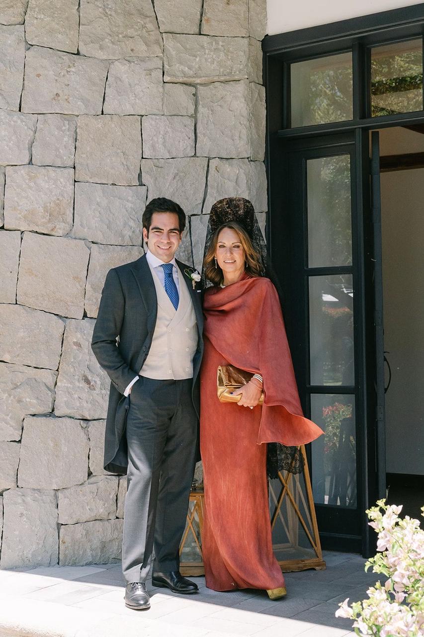 Invitados elegantes en la entrada de piedra del venue