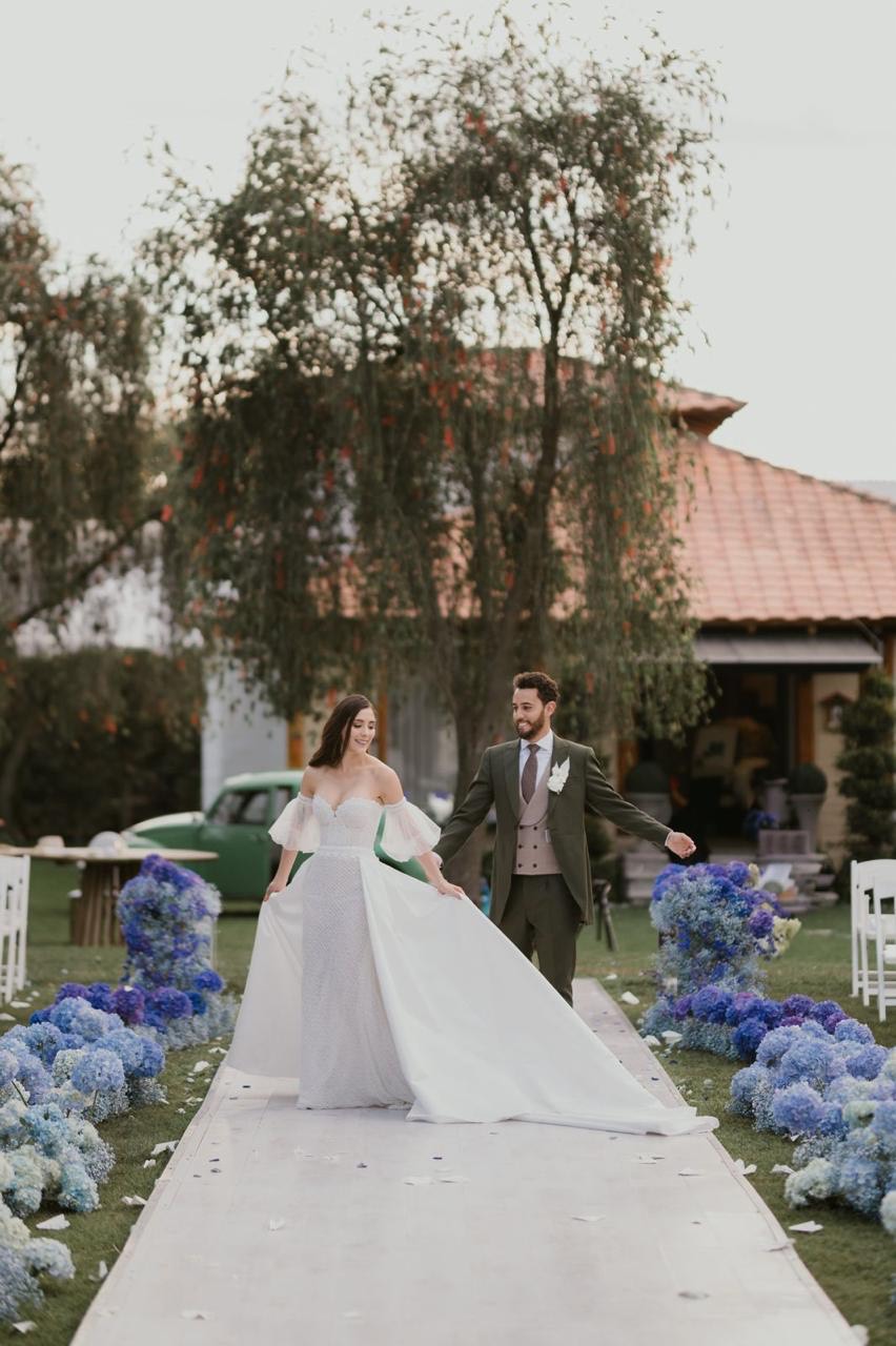 Novios caminando por el pasillo decorado con hortensias azules