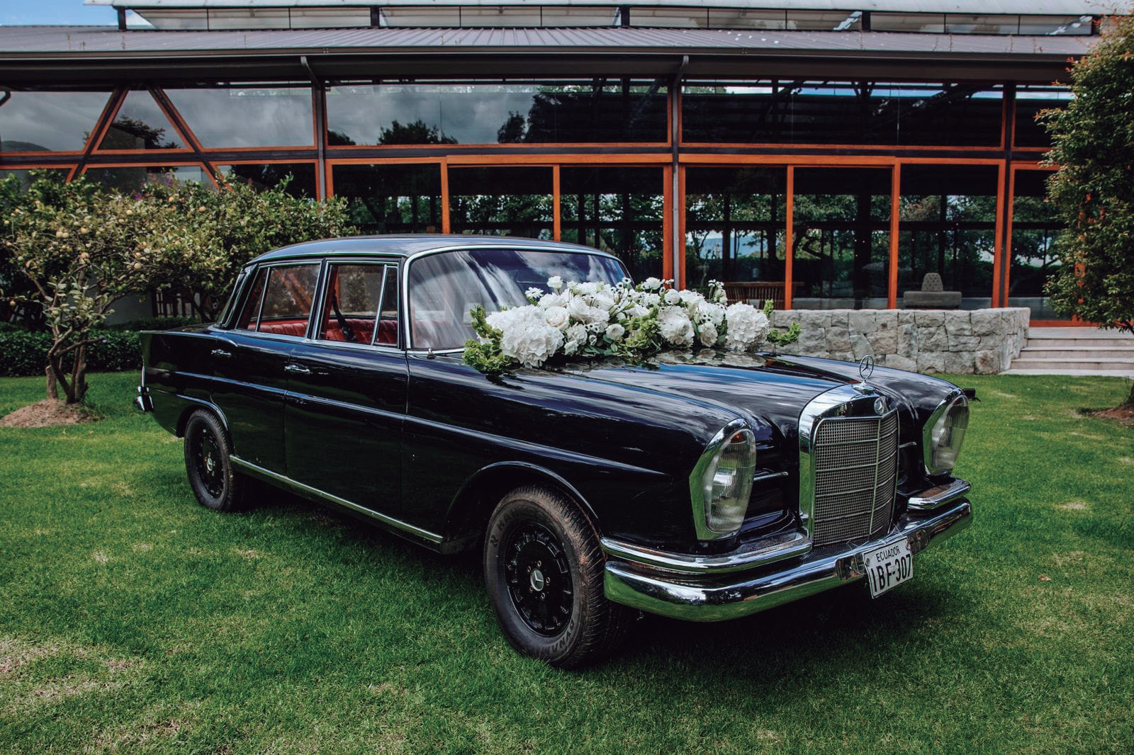 Mercedes clásico negro con flores blancas